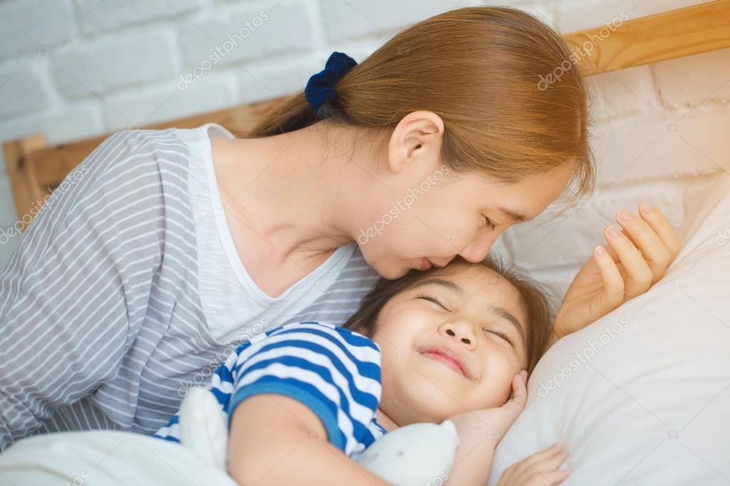 Asian mother and daughter kissing